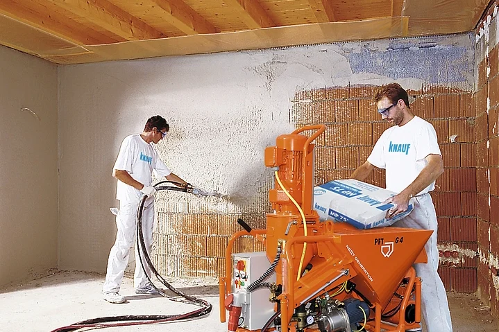 Specialists applying sprayed plaster